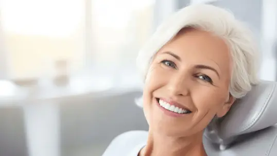 A smiling woman on a dental chair