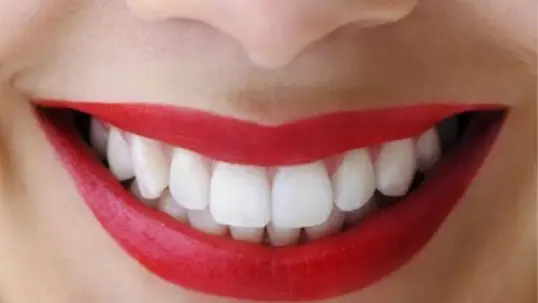 Close-up of a woman's smile with red lipstick